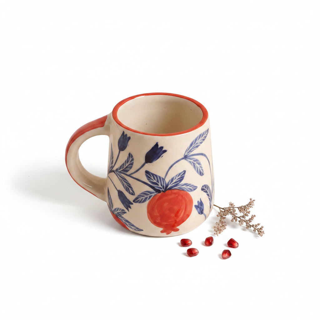 Ceramic mug with floral design and pomegranate illustration on a white background
