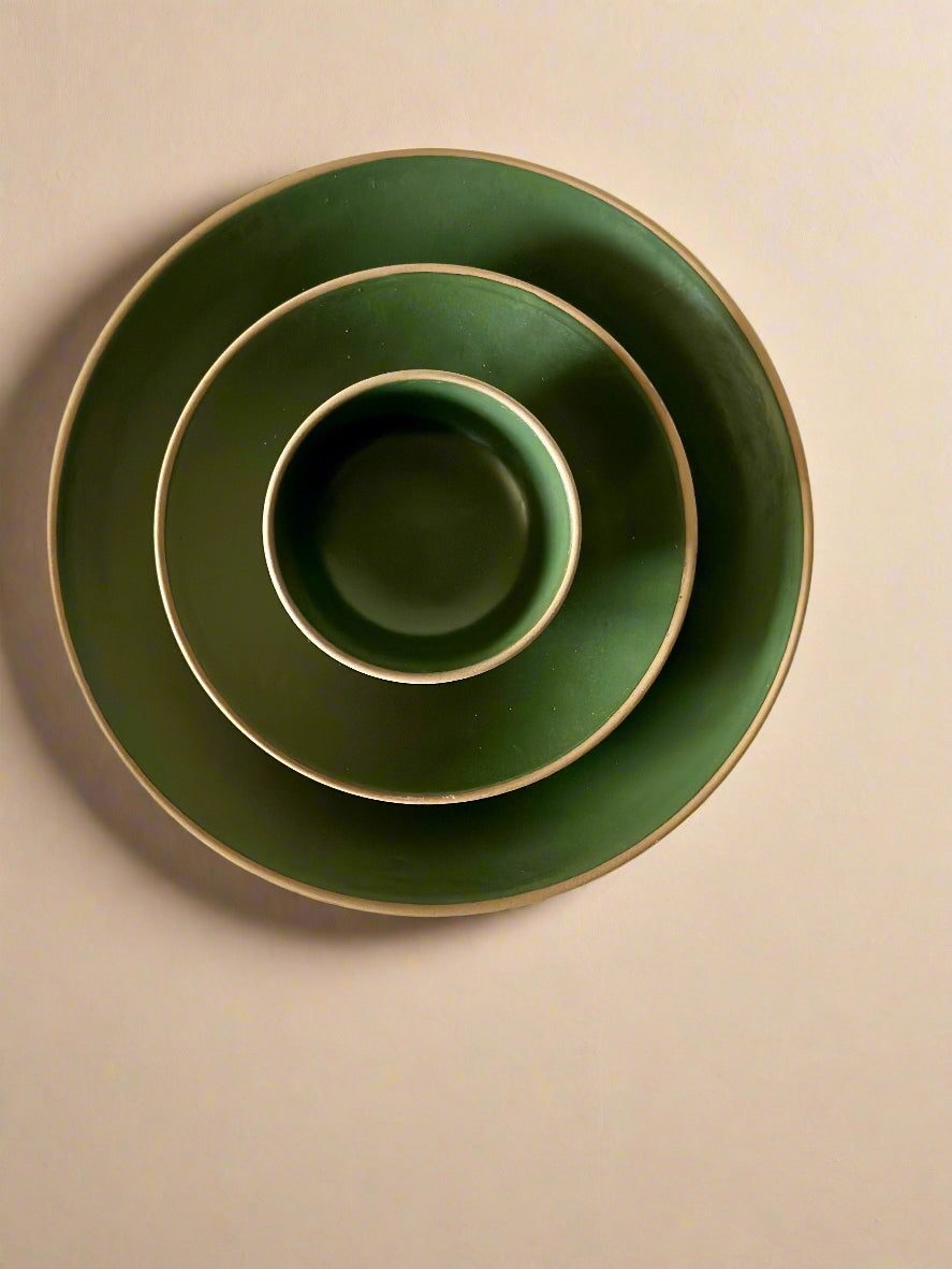 Set of three green ceramic bowls stacked on a light background