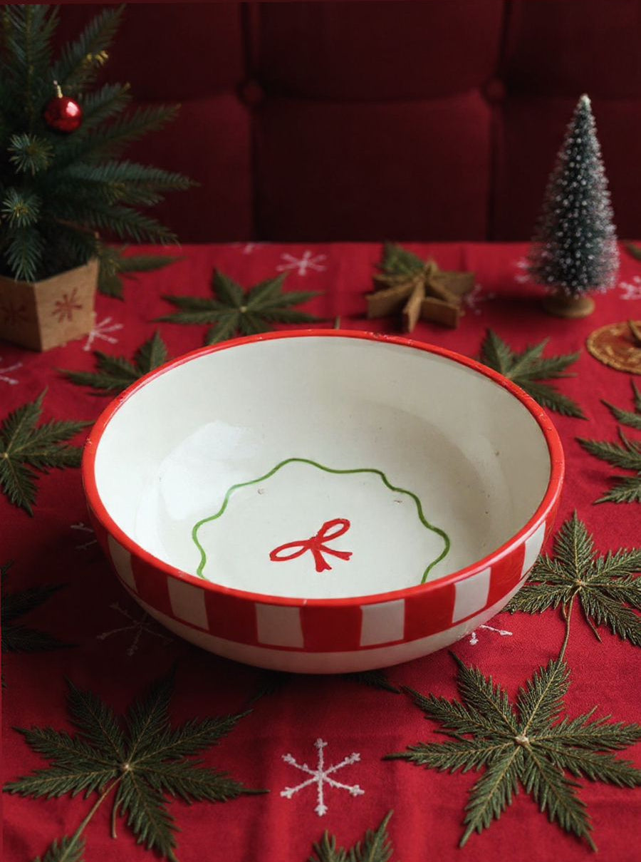 Decorative bowl with a red and white design on a Christmas-themed tablecloth.