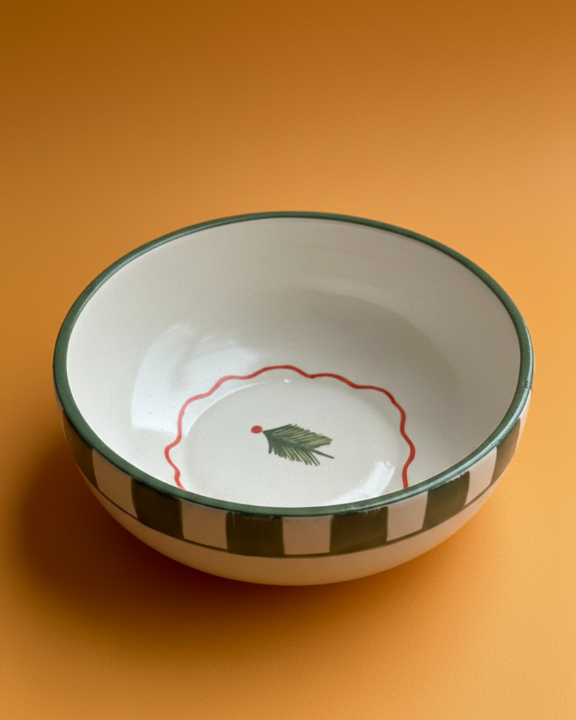 Ceramic bowl with green rim and decorative design on an orange background