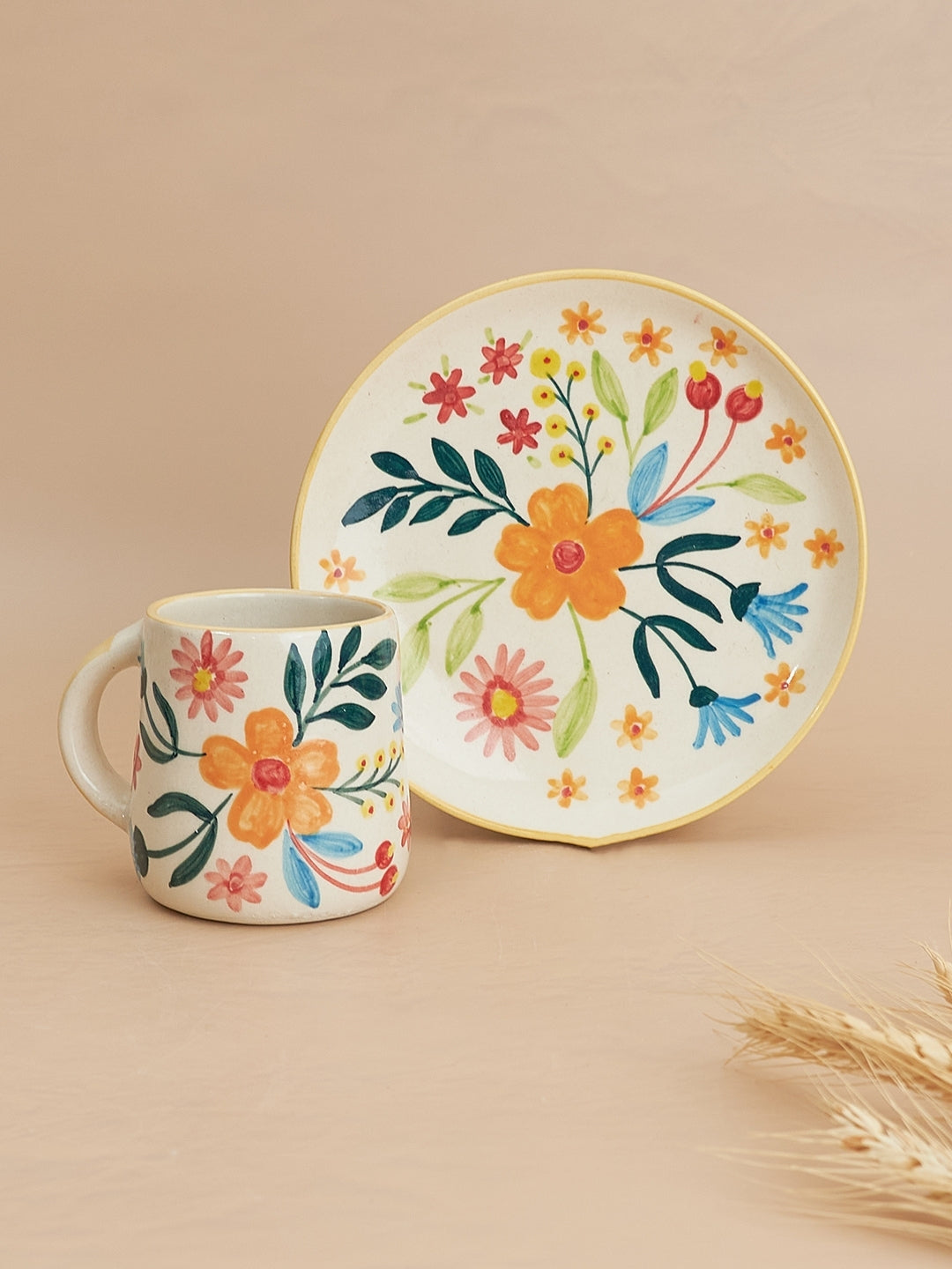 A floral patterned ceramic mug and plate set on a neutral background.