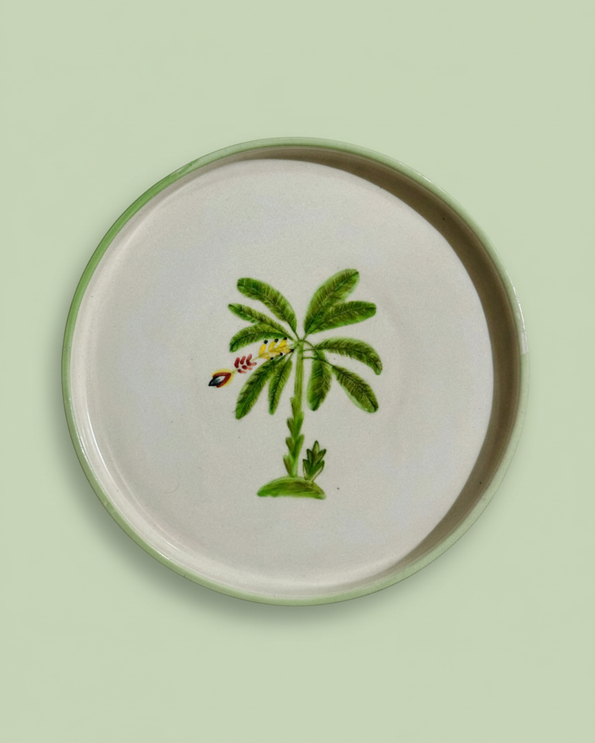 Round ceramic plate with a palm tree design on a light green background