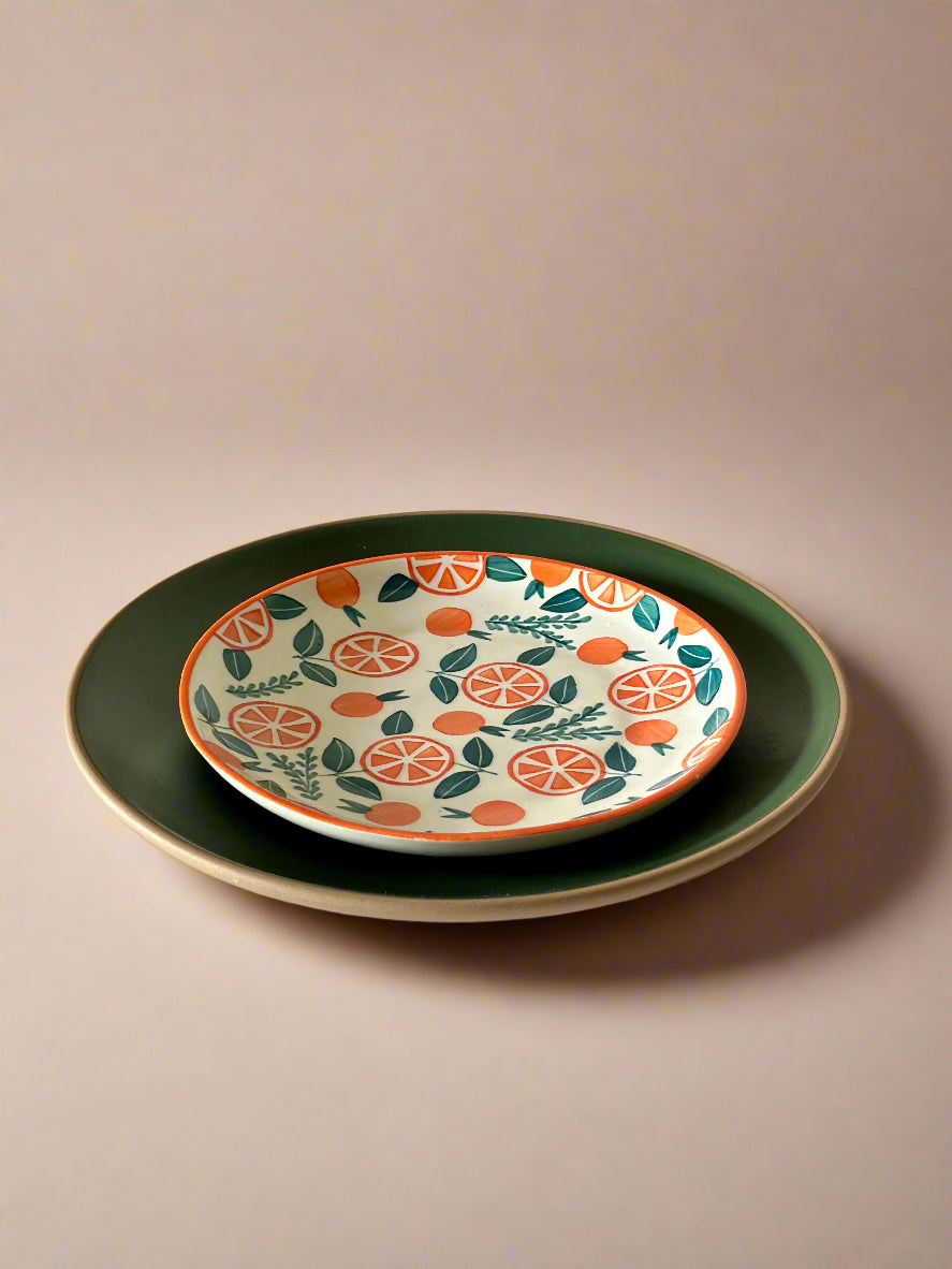 Two ceramic plates stacked on a white surface with a plain background