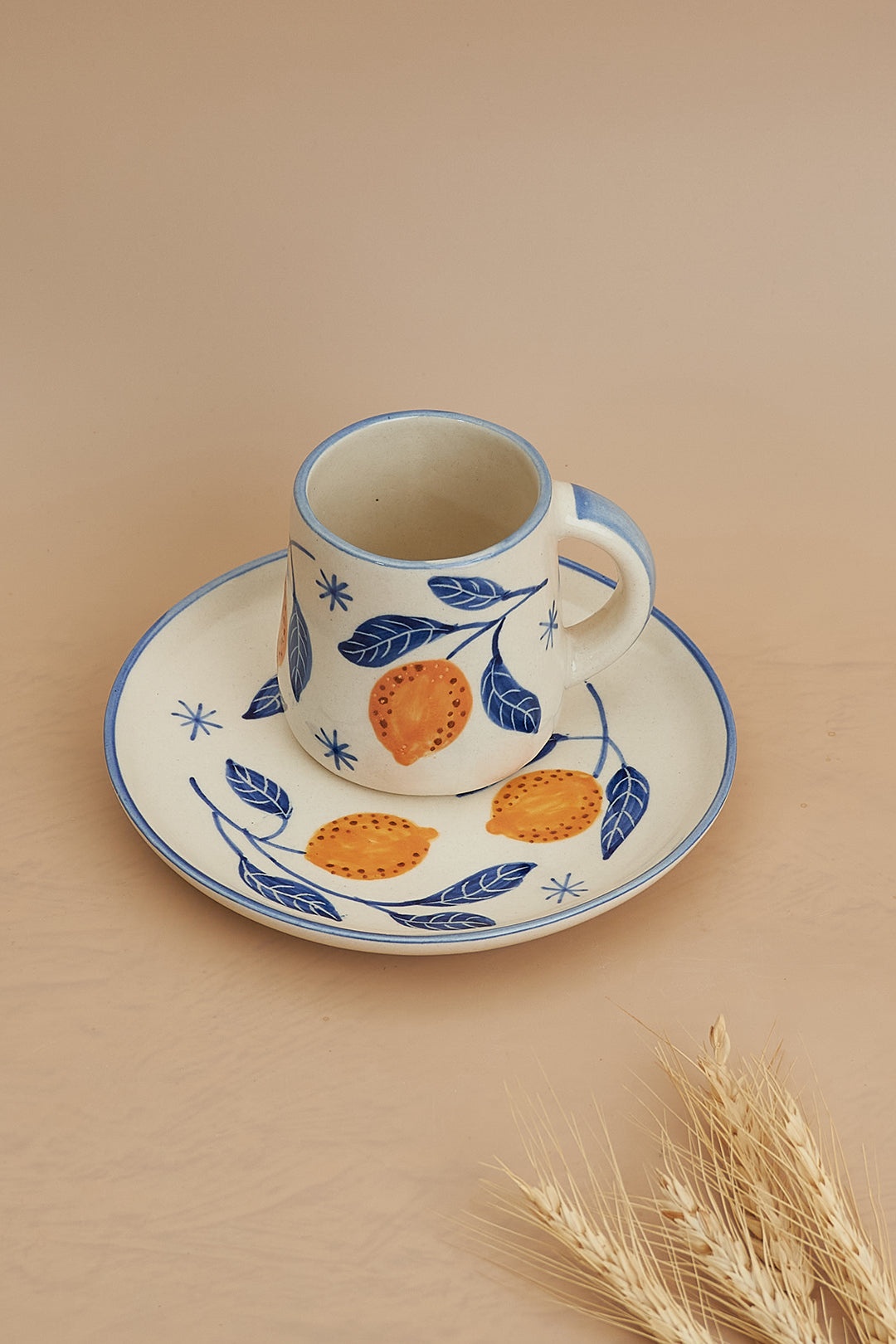 A set of breakfastware with a floral pattern, predominantly featuring yellow and green colors, on a beige background.