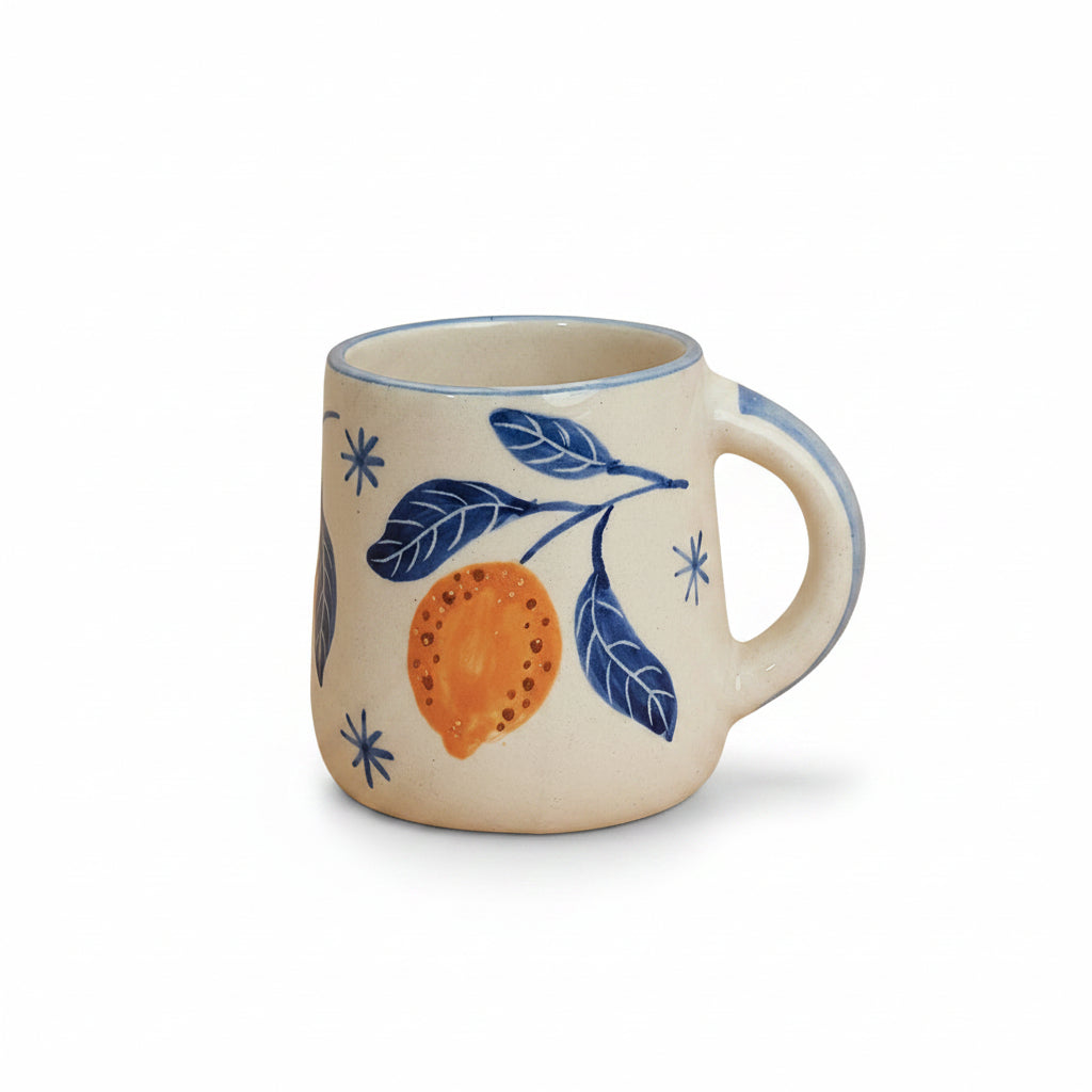 Ceramic mug with blue leaf and orange design on a beige background