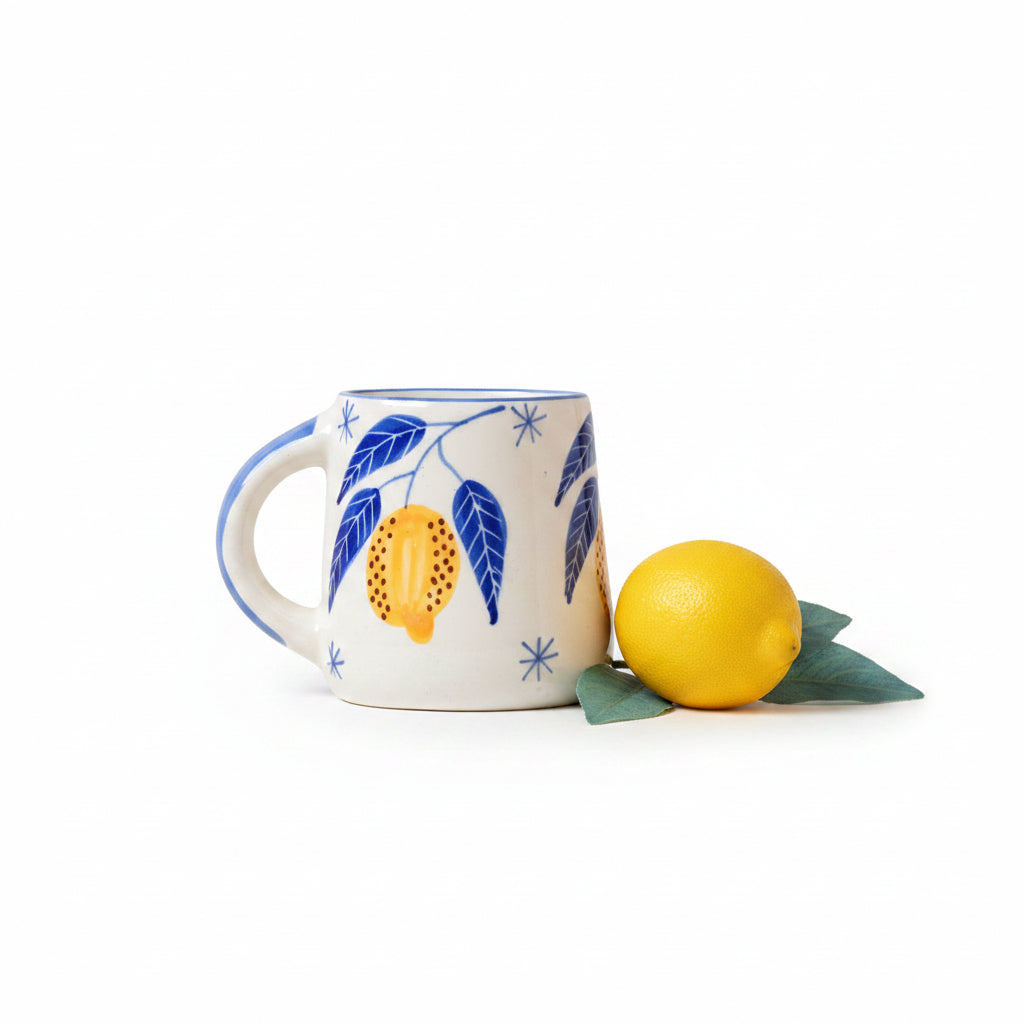 Ceramic mug with lemon and leaf design on a beige background