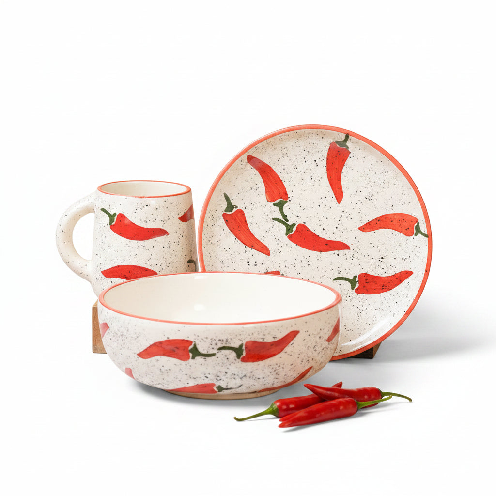 Ceramic set with bowl, mug, and plate featuring red chili pepper design on a beige background