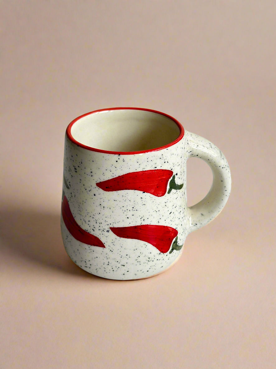Ceramic mug with red chili pepper design on a white background