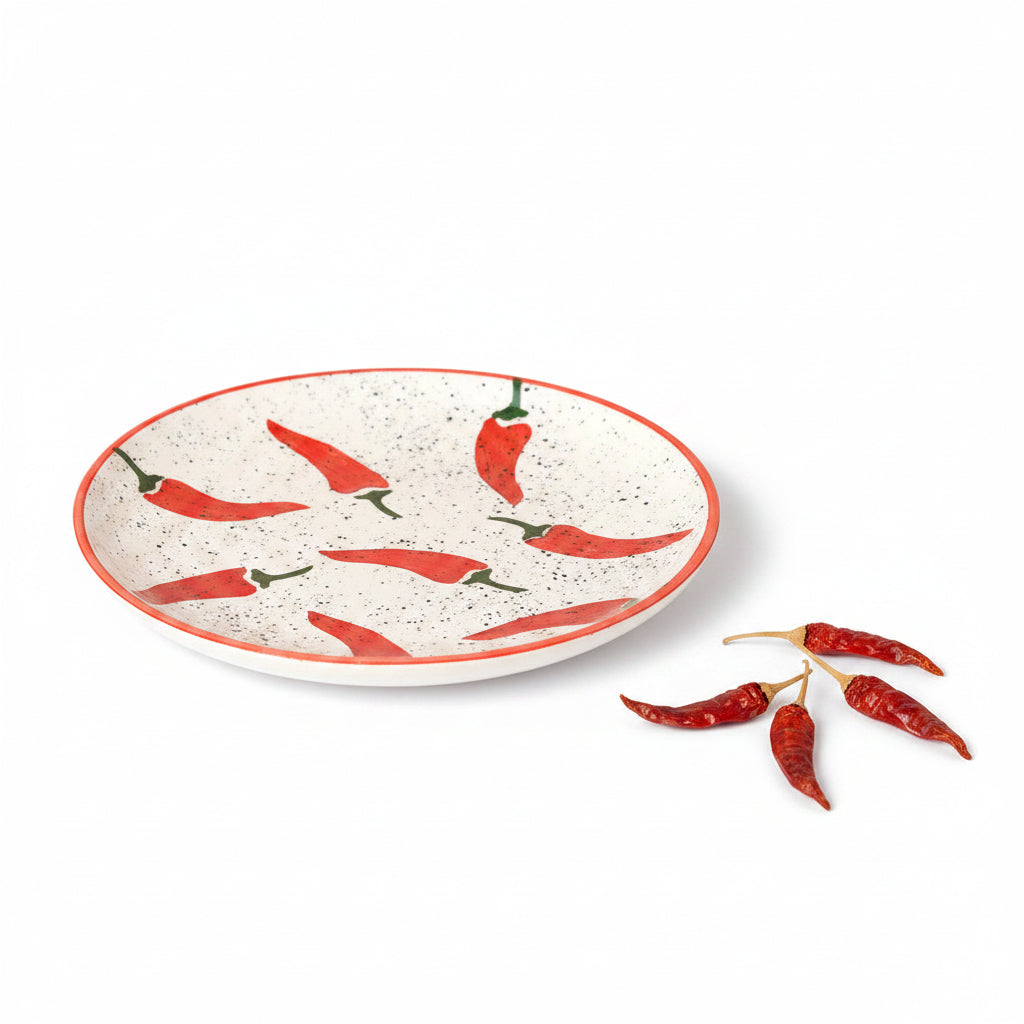 Ceramic plate with red chili pepper design on a beige background