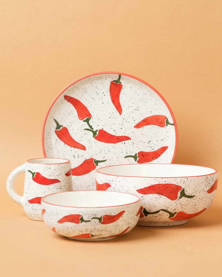 Ceramic dinnerware set with red chili pepper design on a beige background