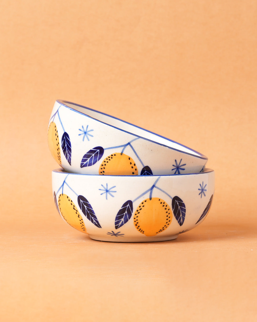 Two ceramic bowls with lemon design on a beige background
