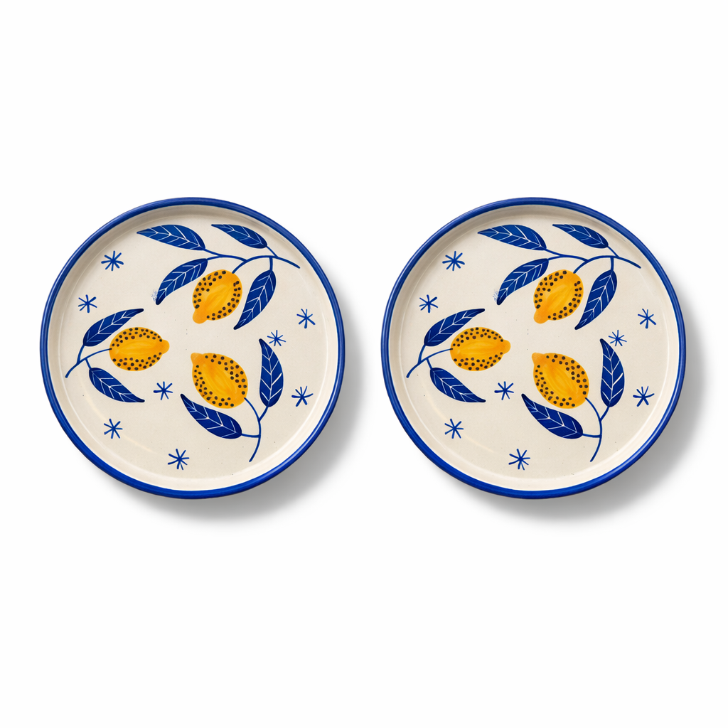 Two ceramic plates with lemon and leaf design on a white background