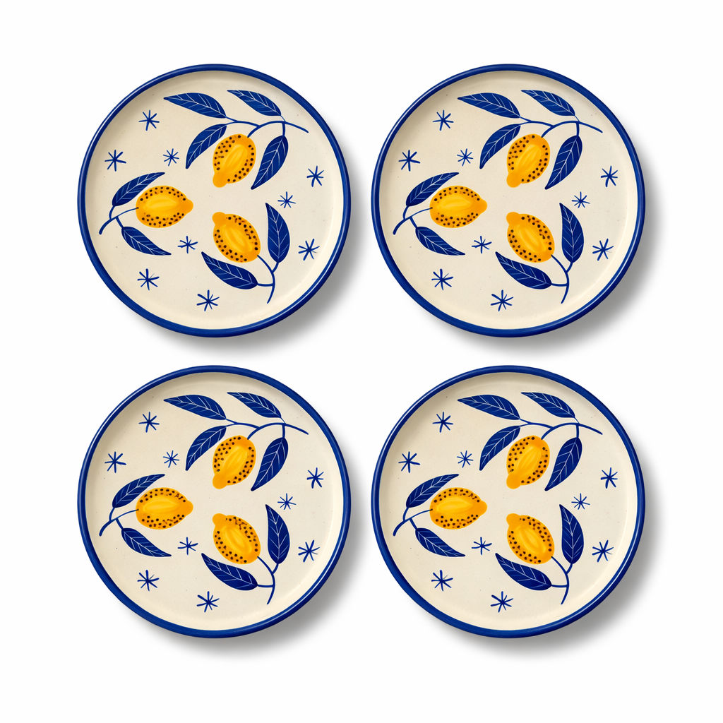 Four ceramic plates with lemon and leaf pattern on a white background