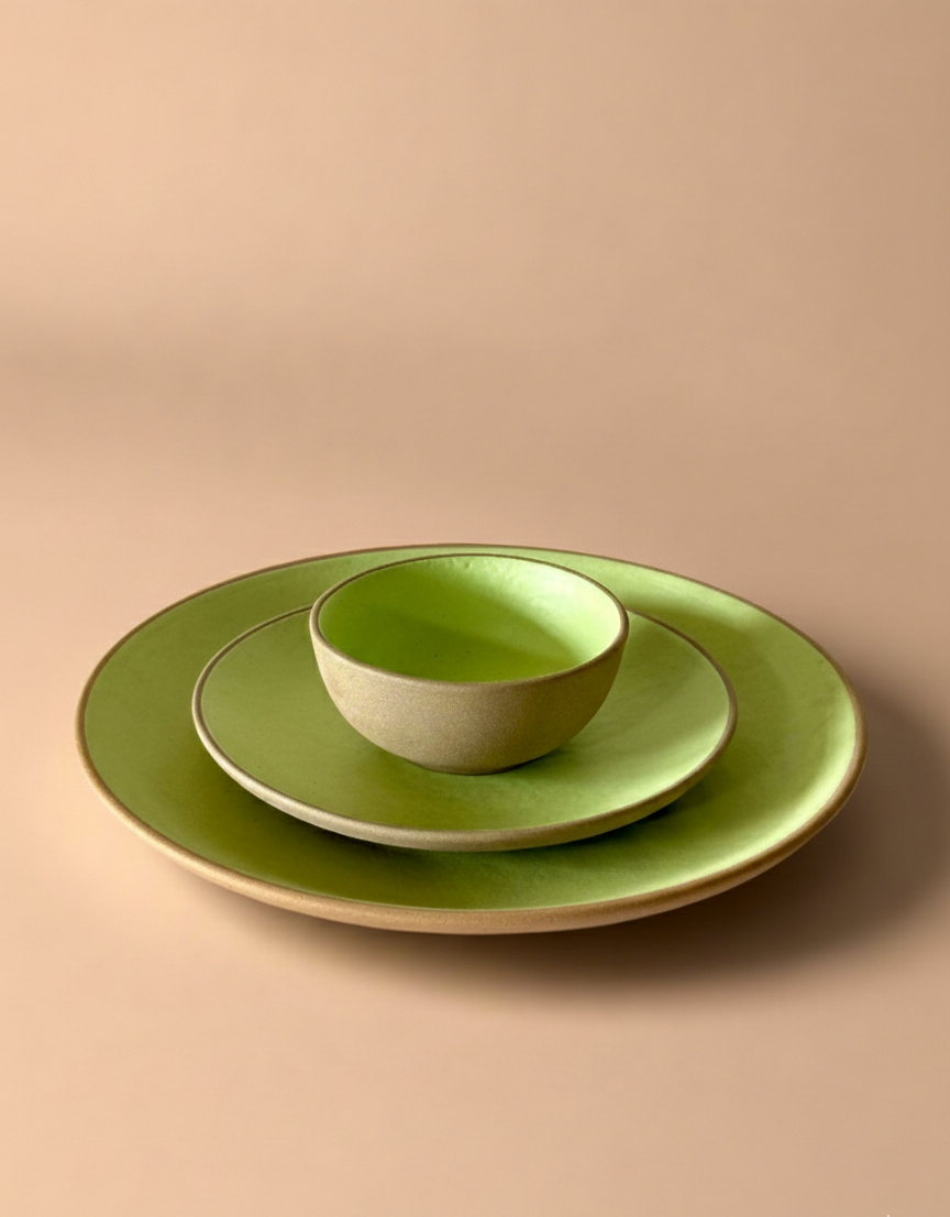 Set of green ceramic plates on a beige background