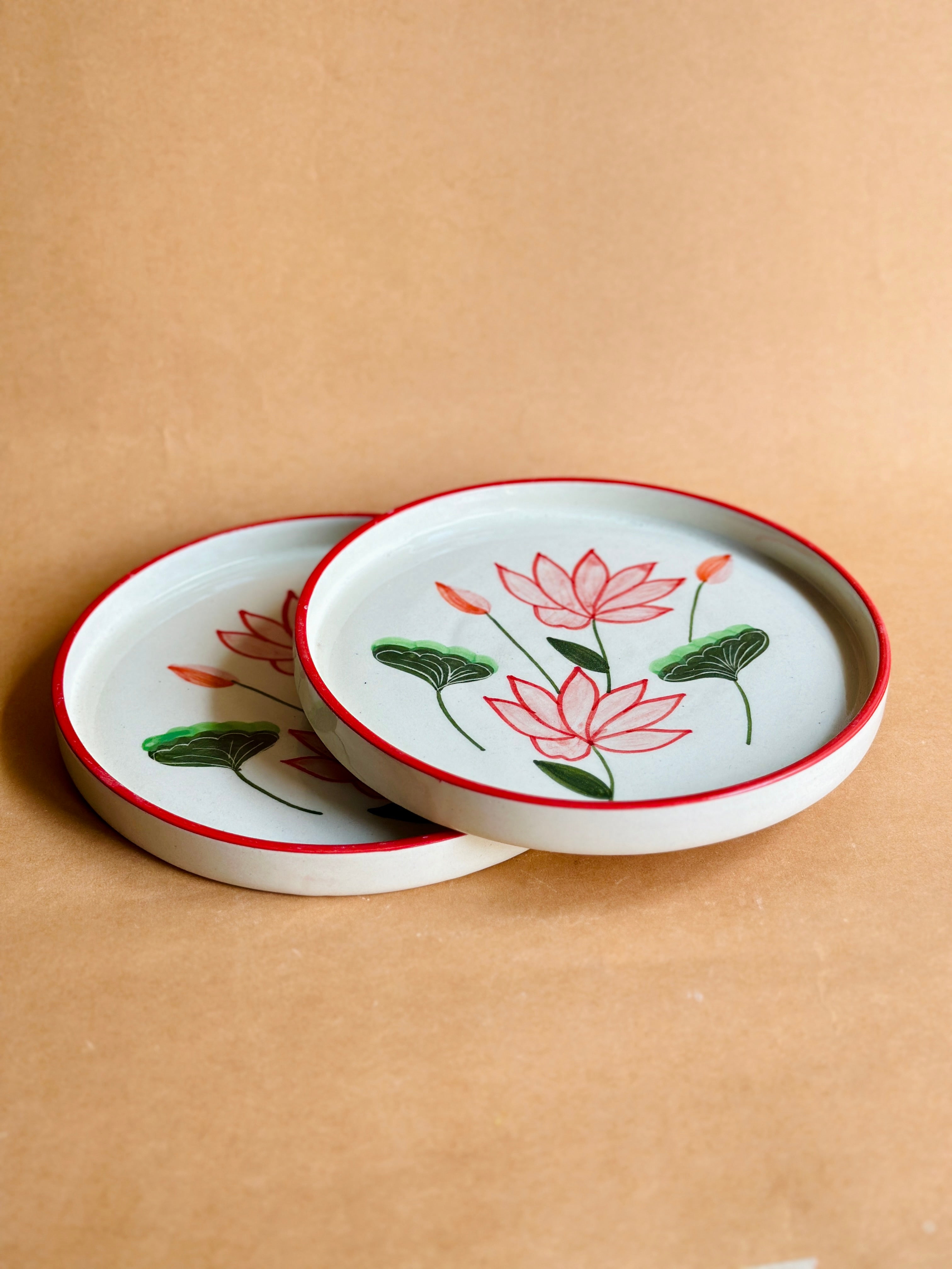 Set of ceramic coasters with lotus designs on a beige background