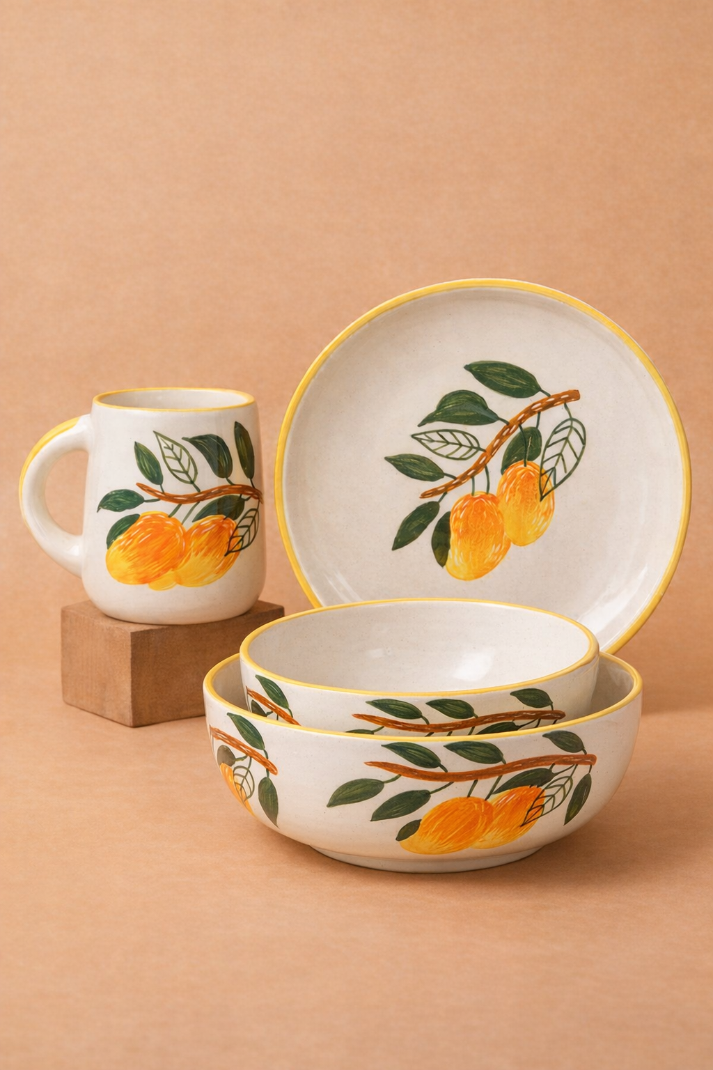 Ceramic set with bowls and a mug featuring mango and leaf design on a beige background