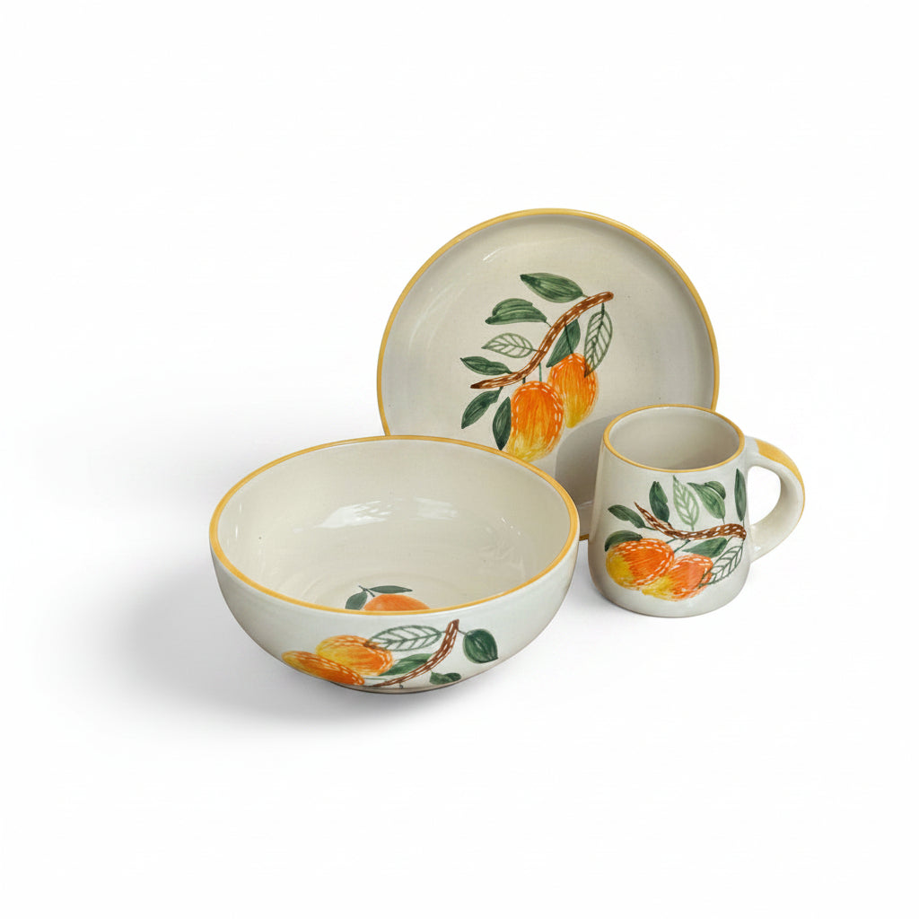 Ceramic dishes with orange and leaf design on a metallic surface