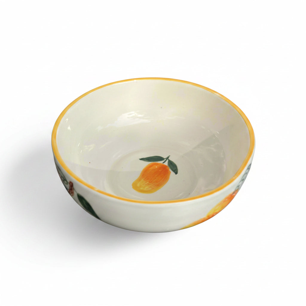 Ceramic bowl with fruit design on a reflective surface