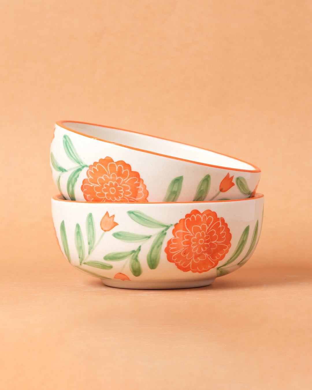 Two ceramic bowls with floral patterns on a peach background