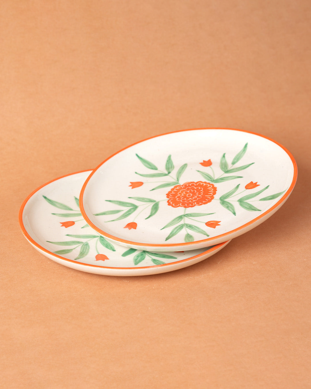 Two ceramic plates with floral designs on a beige background