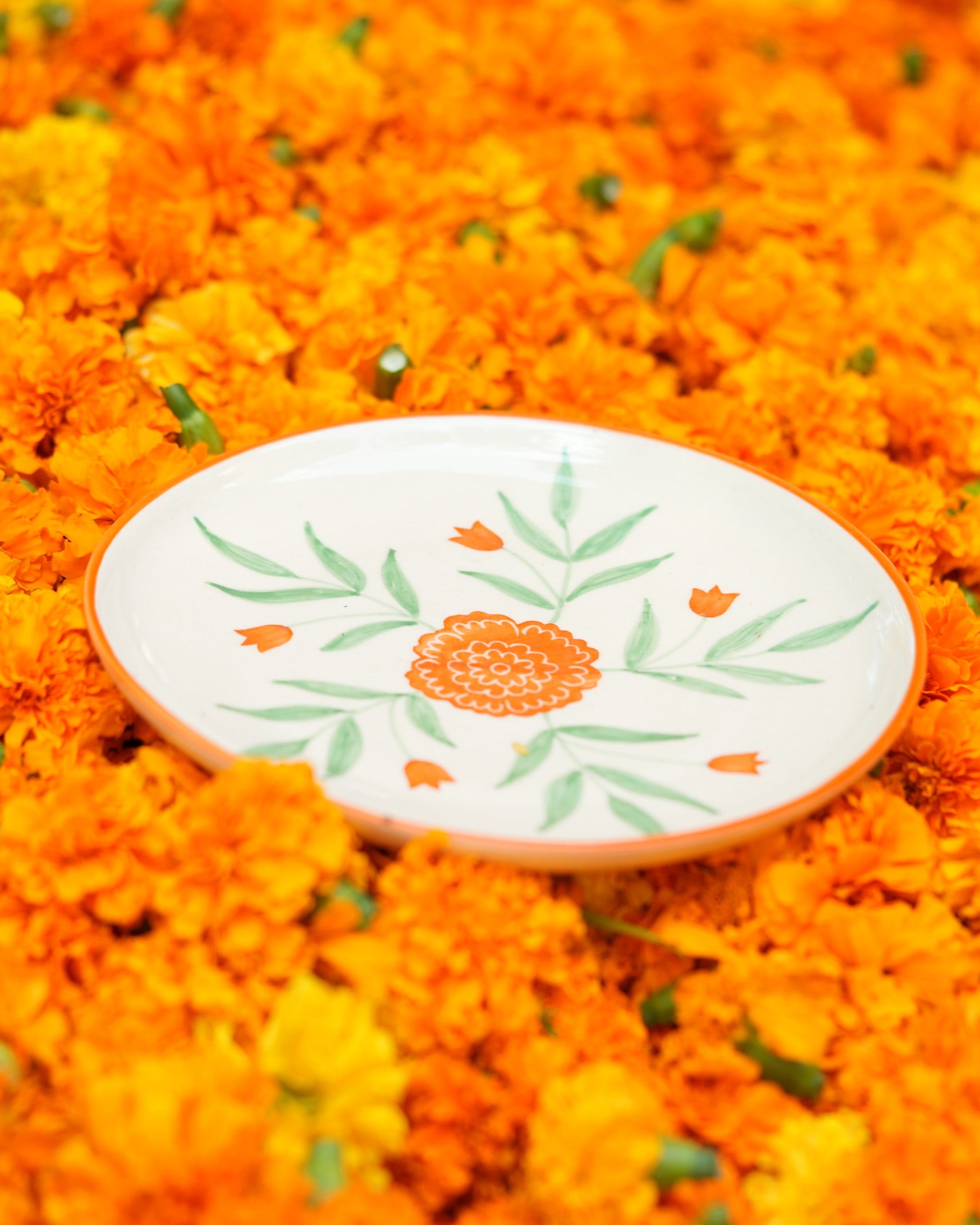 Decorative plate with floral design on a bed of orange flowers