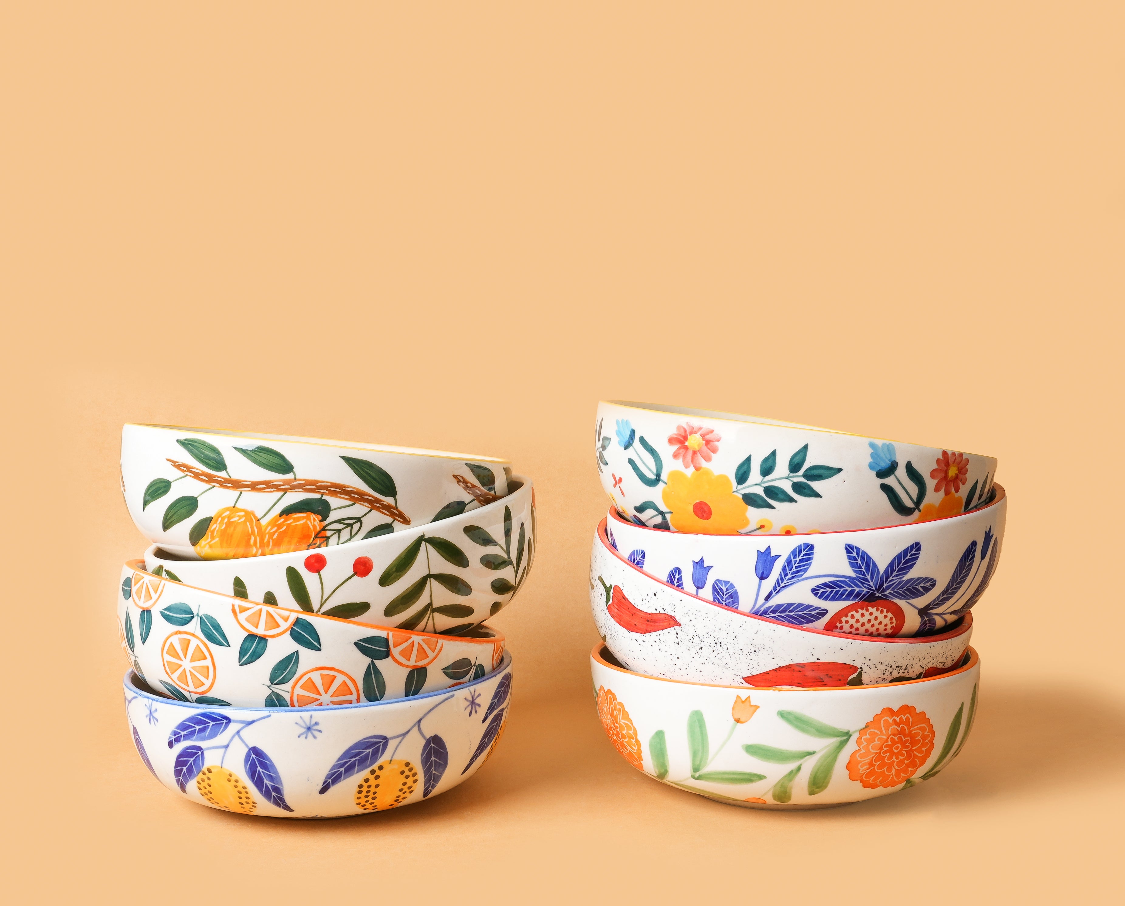 Set of decorative bowls with floral and fruit patterns on a beige background