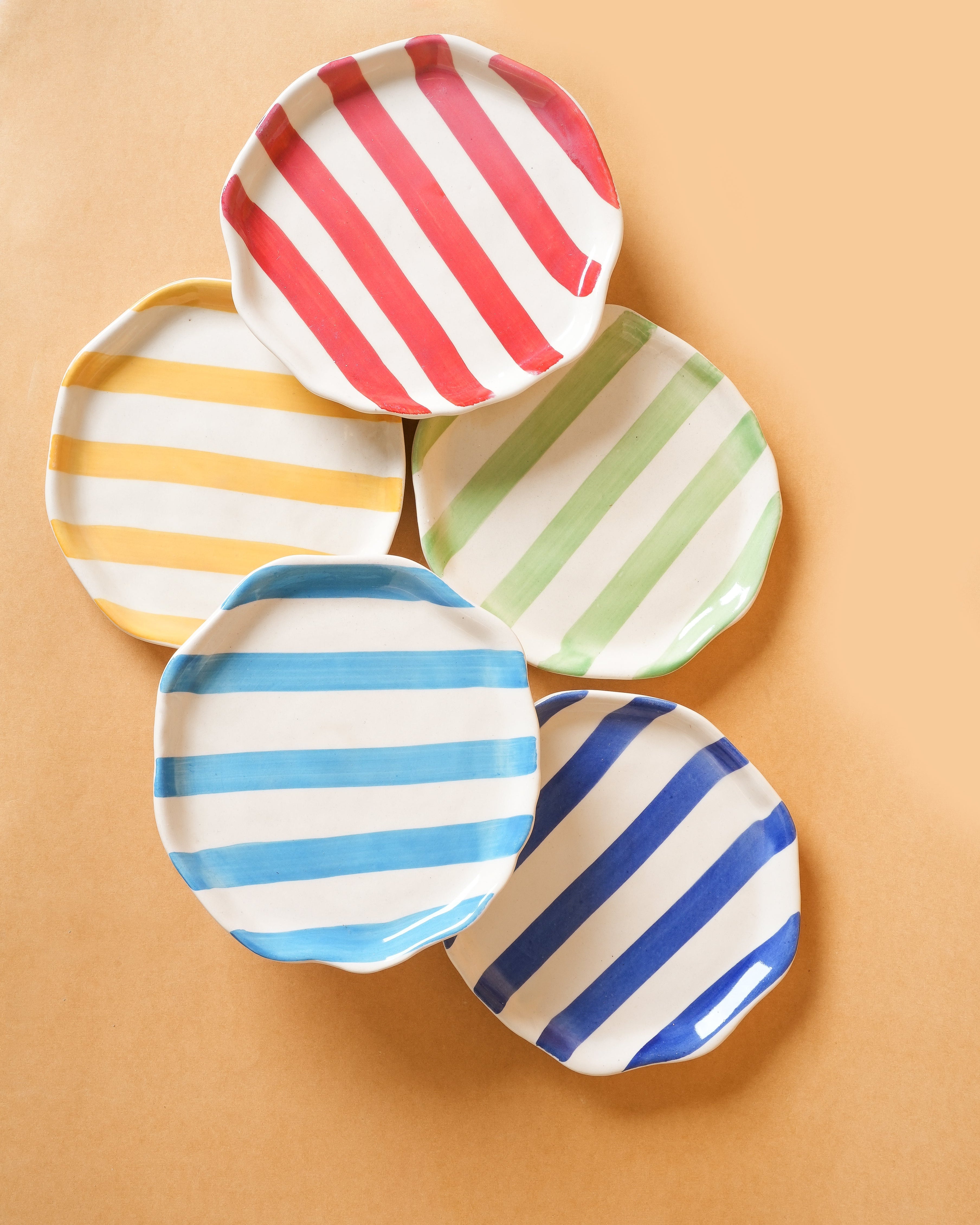Set of colorful striped plates on a beige background