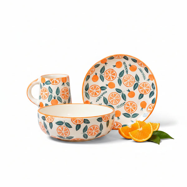 Ceramic tableware set with orange and leaf pattern on a white background