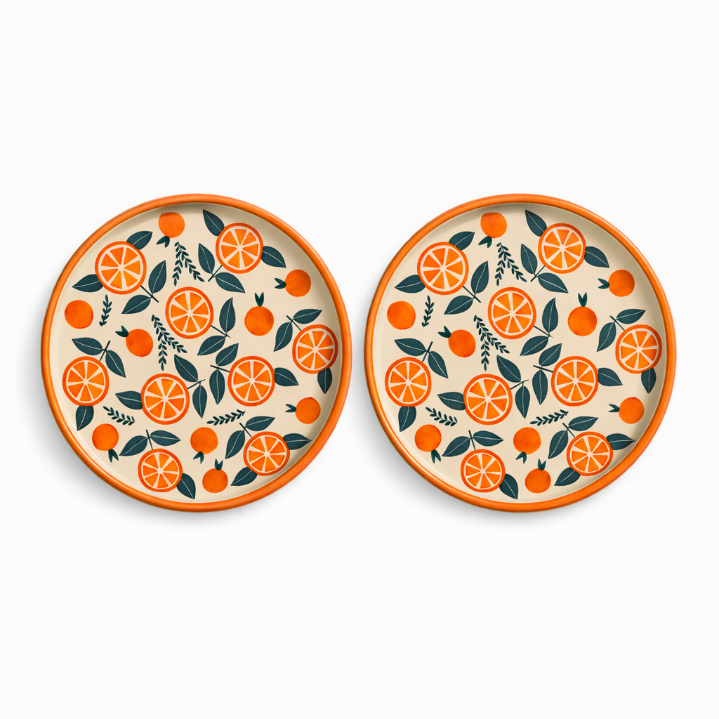 Two ceramic plates with orange and leaf pattern on a white background