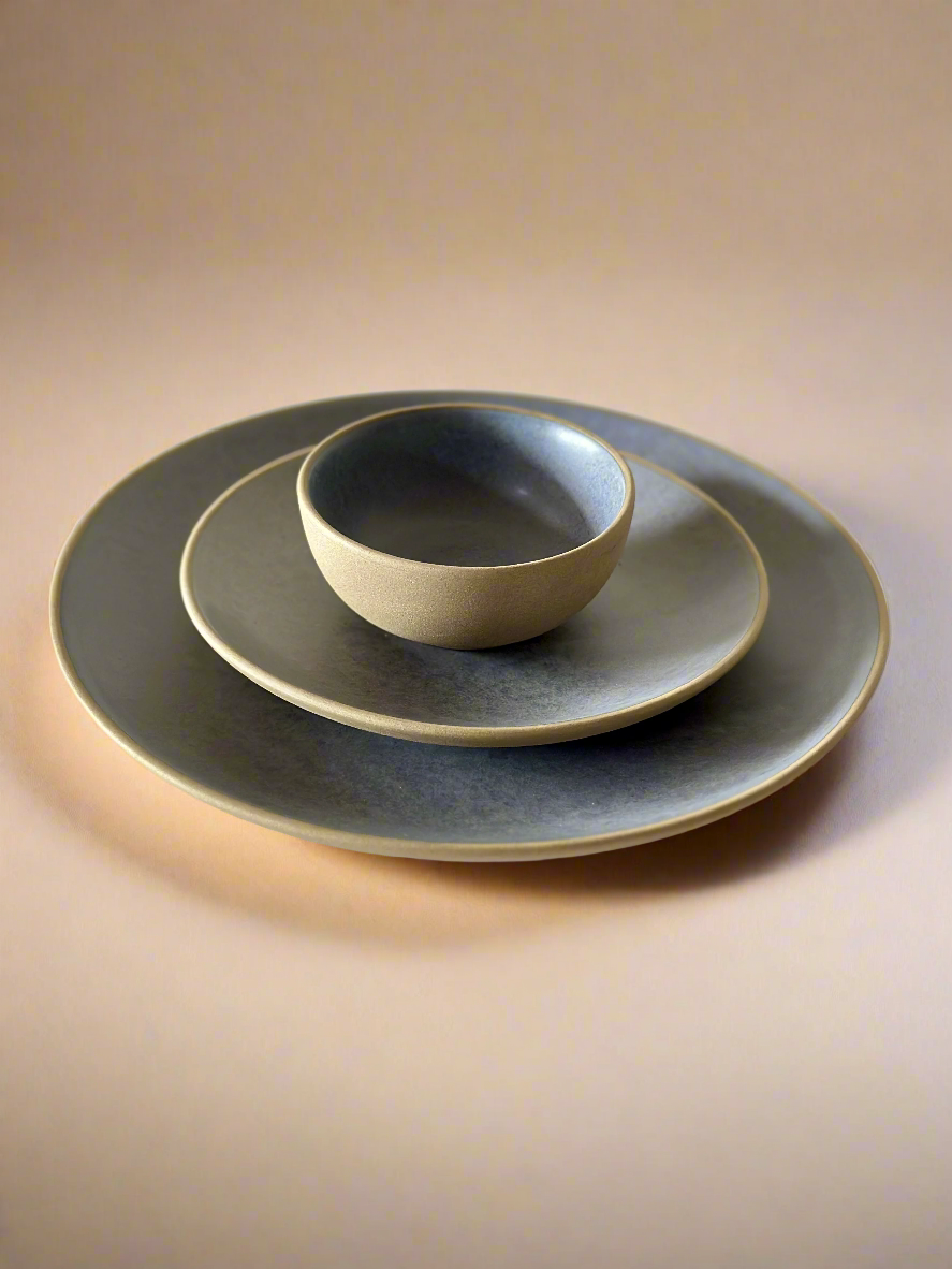 Set of ceramic plates and bowl on a light background