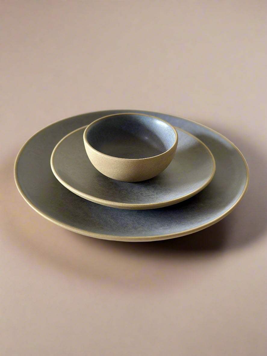 Set of ceramic plates and bowl on a light background