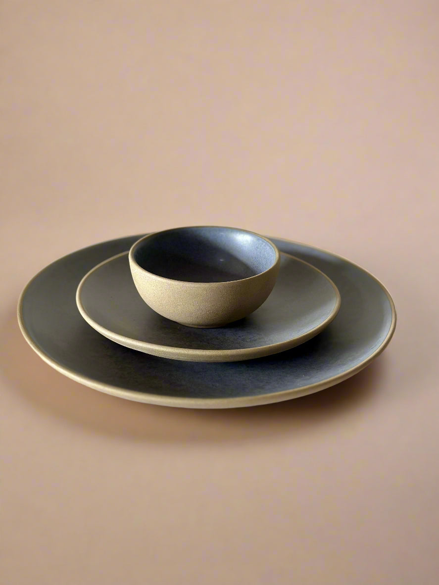 Set of three ceramic plates with a bowl on a light gray background