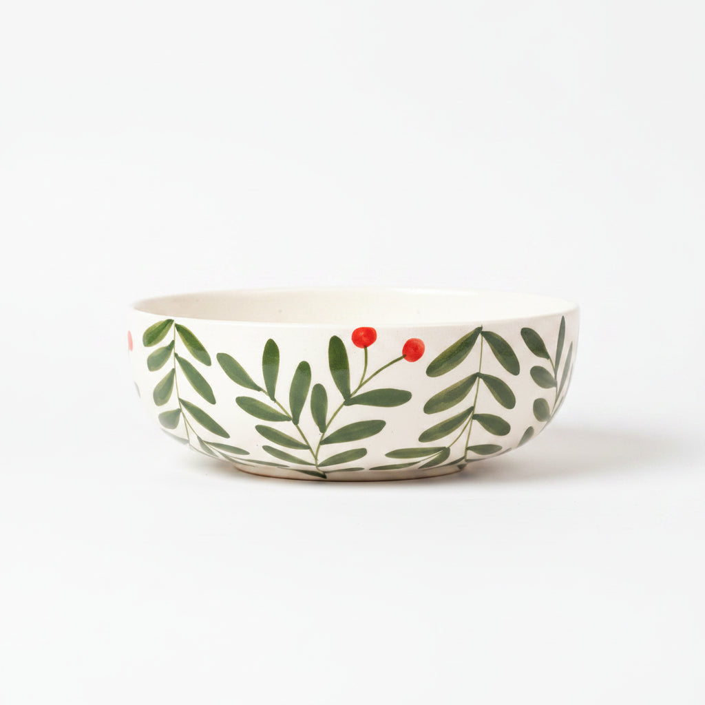 Ceramic bowl with leaf and berry design on a beige background