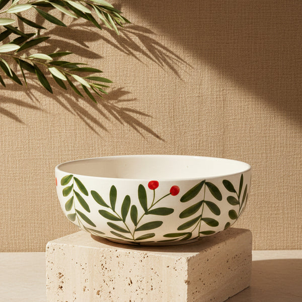 Ceramic bowl with leaf and berry design on a beige background