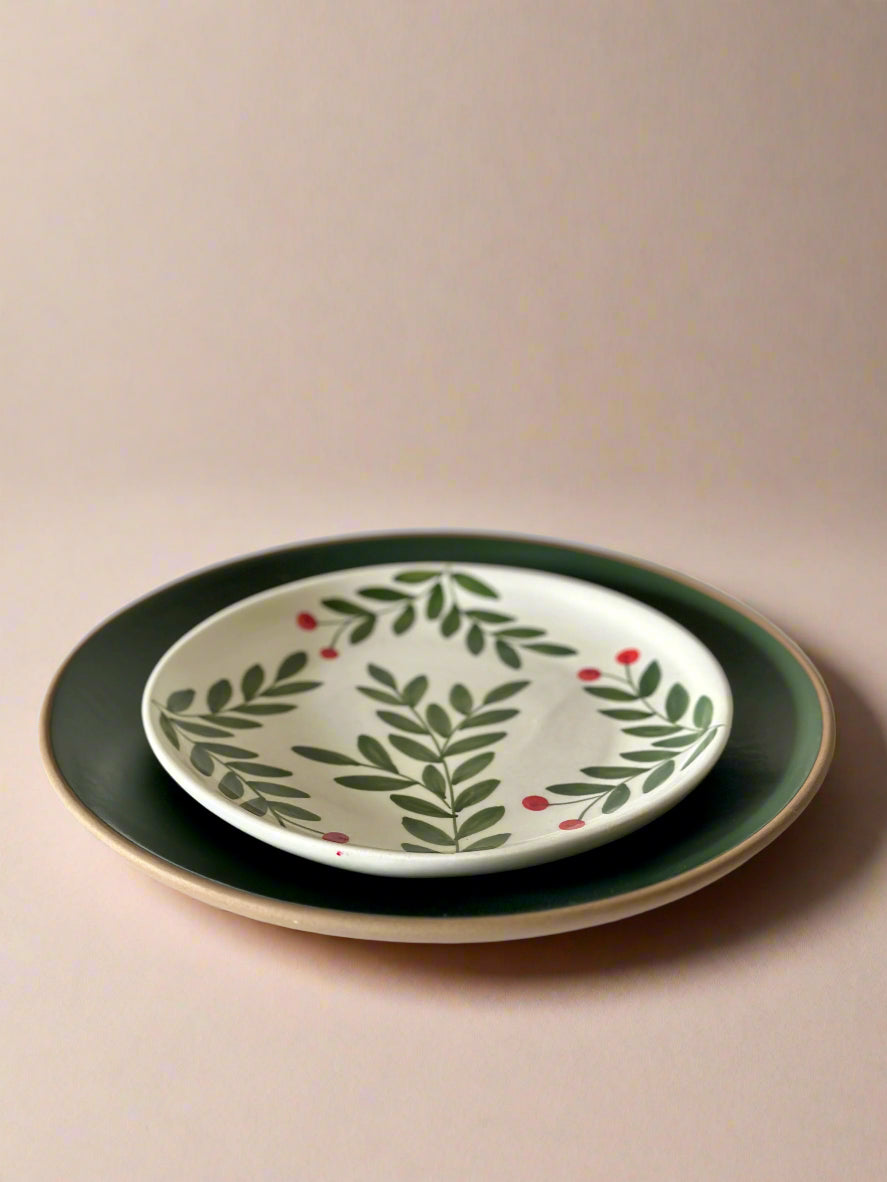 Set of two ceramic plates with leaf pattern on a beige background
