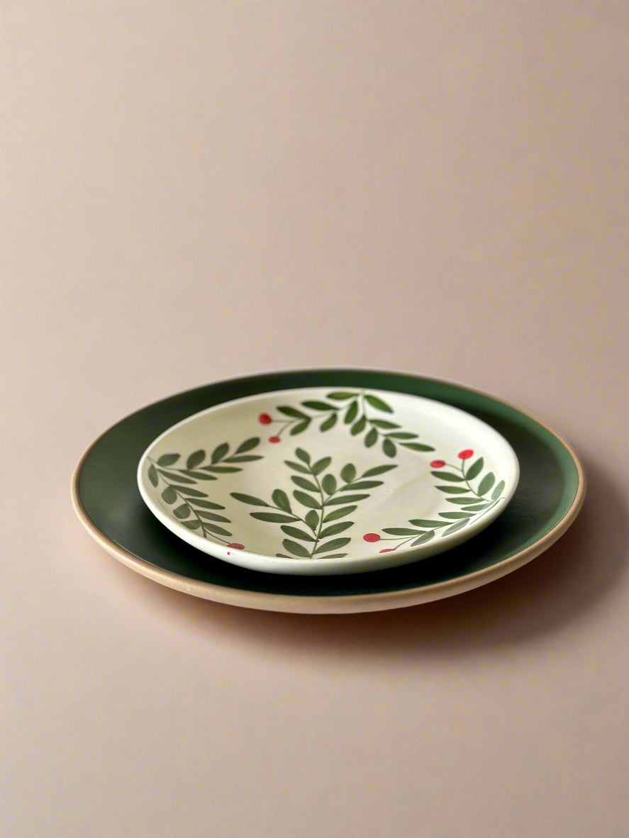 Set of two ceramic plates with leaf pattern on a beige background