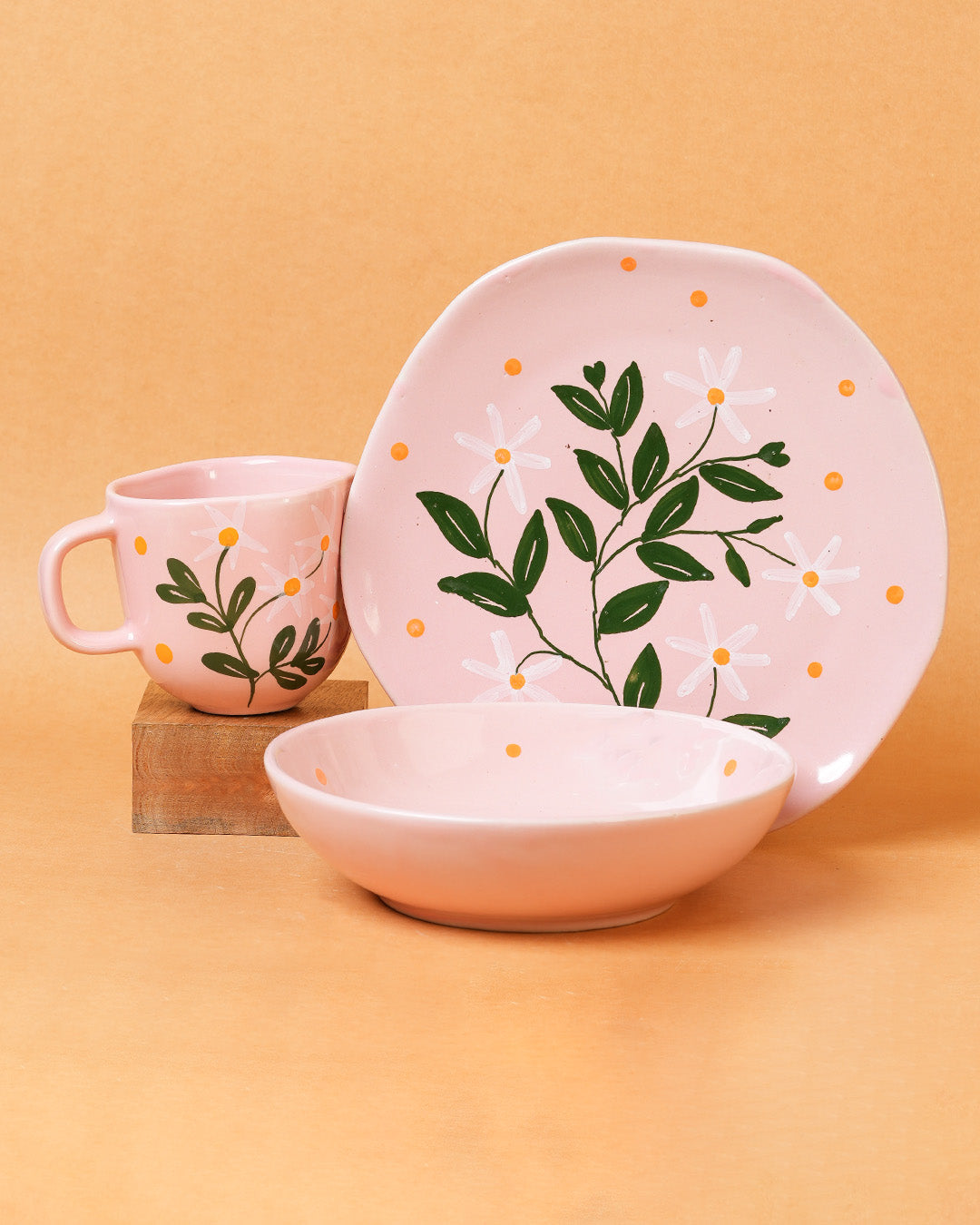 Pink ceramic set with floral design on a beige background