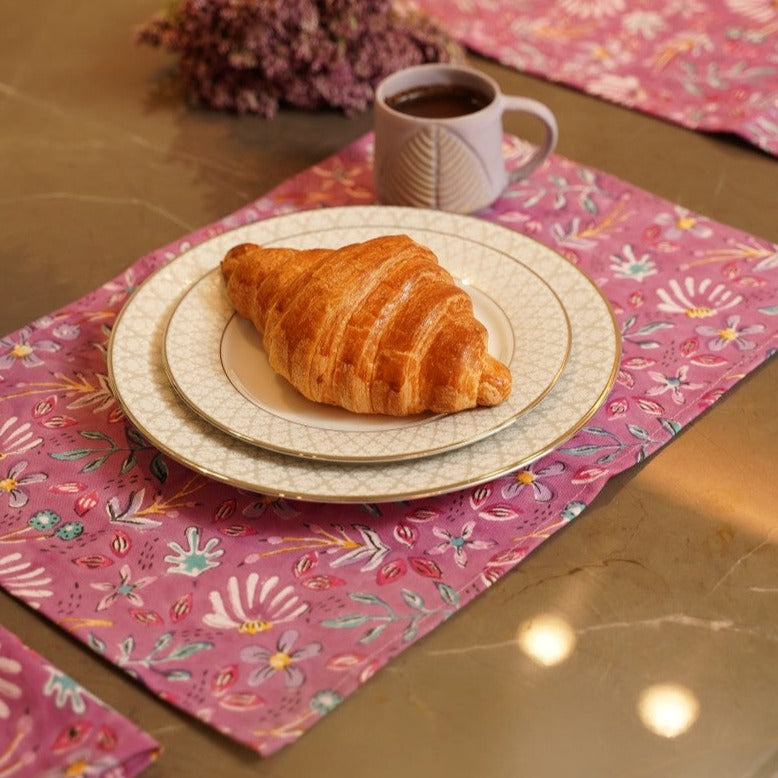 a croissant sitting on a plate next to a cup of coffee