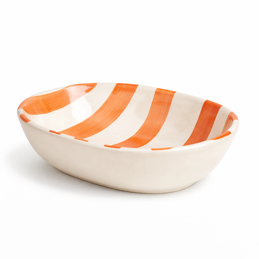 Ceramic bowl with orange and white stripes on a white background