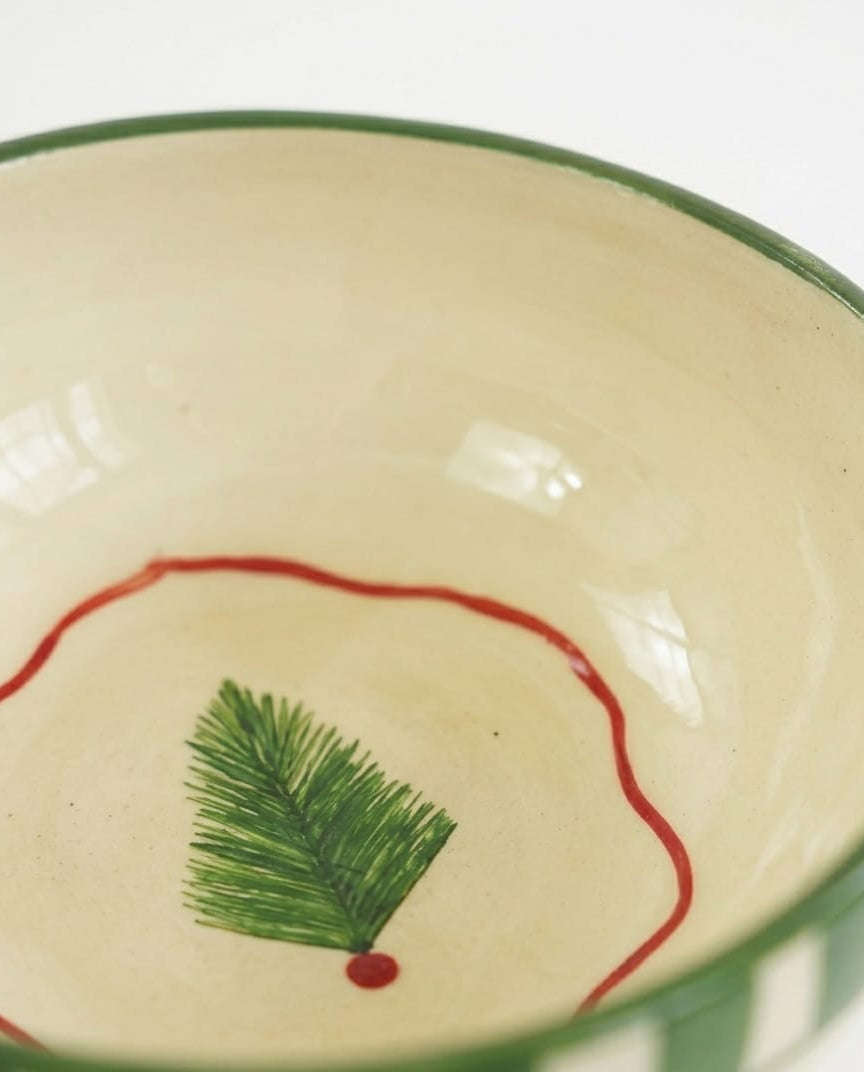 Ceramic bowl with green rim and decorative design on a white background