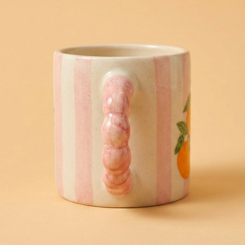 Pink striped handcrafted ceramic mug with orange fruit design