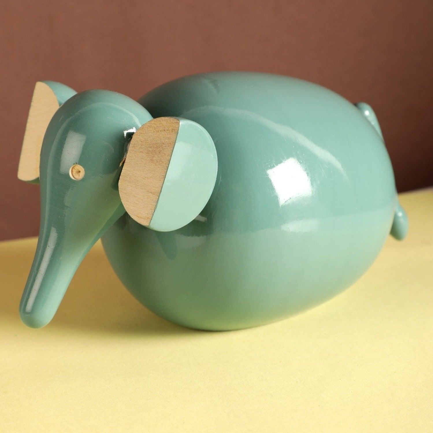 a green ceramic elephant figurine sitting on a table