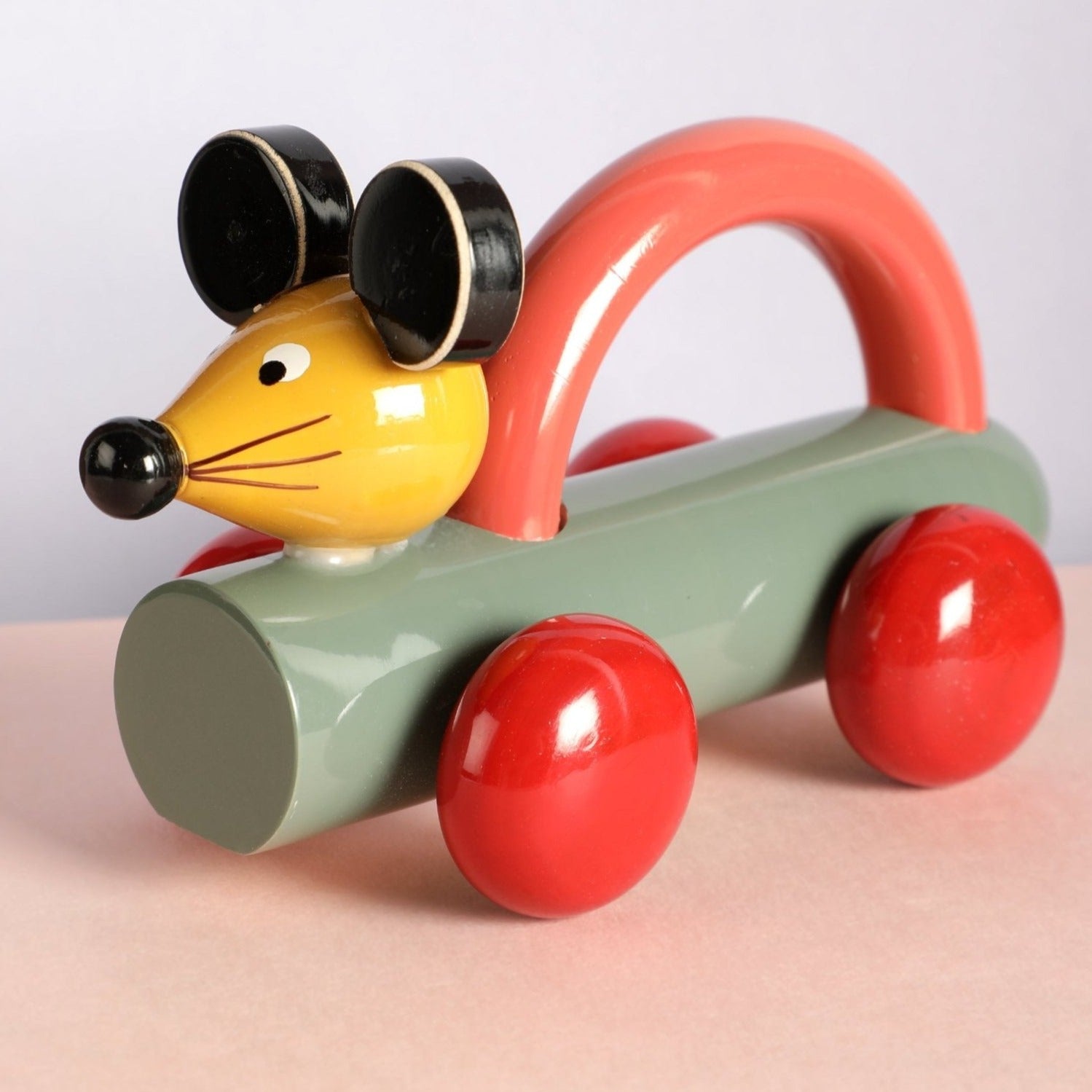 a toy mouse driving a toy car on a table